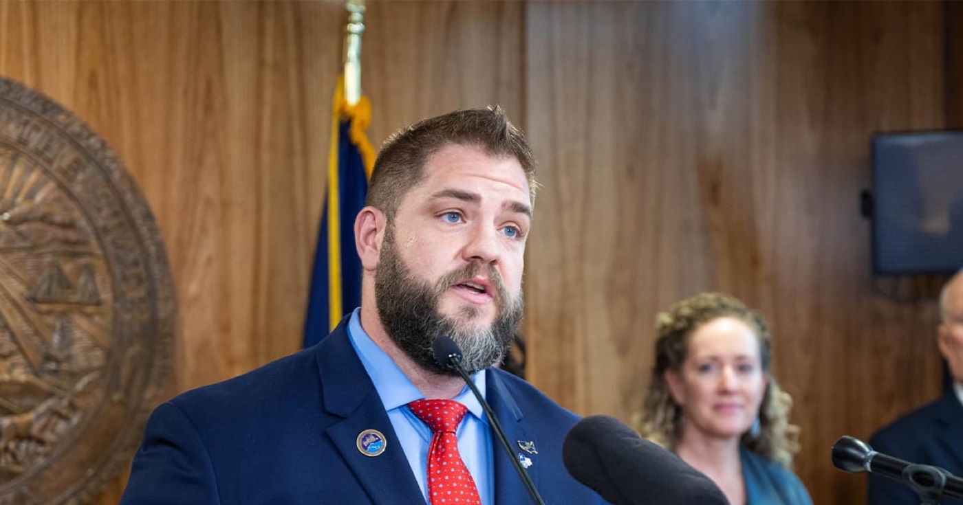 Adam Crum speaking at a podium in Alaska