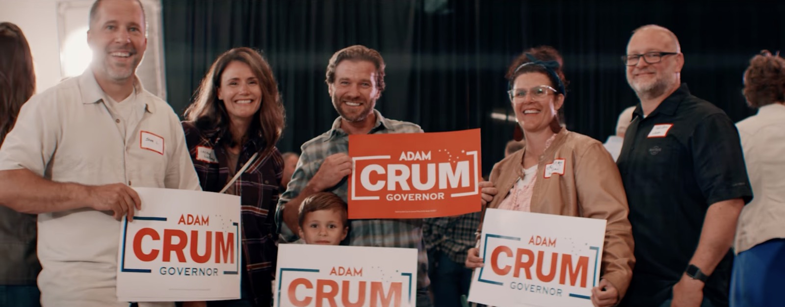 Alaskans holding Adam Crum for Governor signs